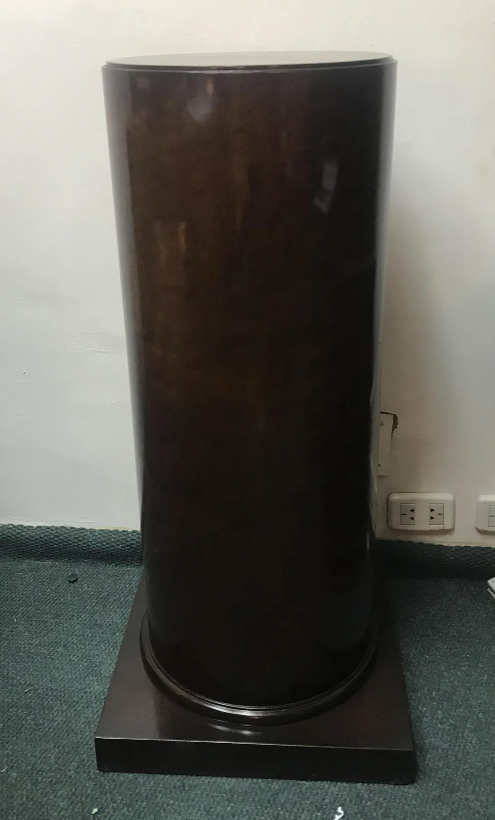 Antique decorative column with base in a neutral setting