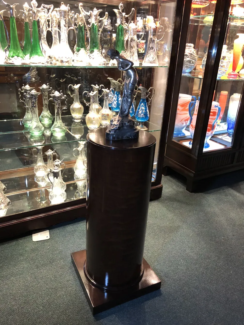 Antique decorative column with a figure, in an antiques setting