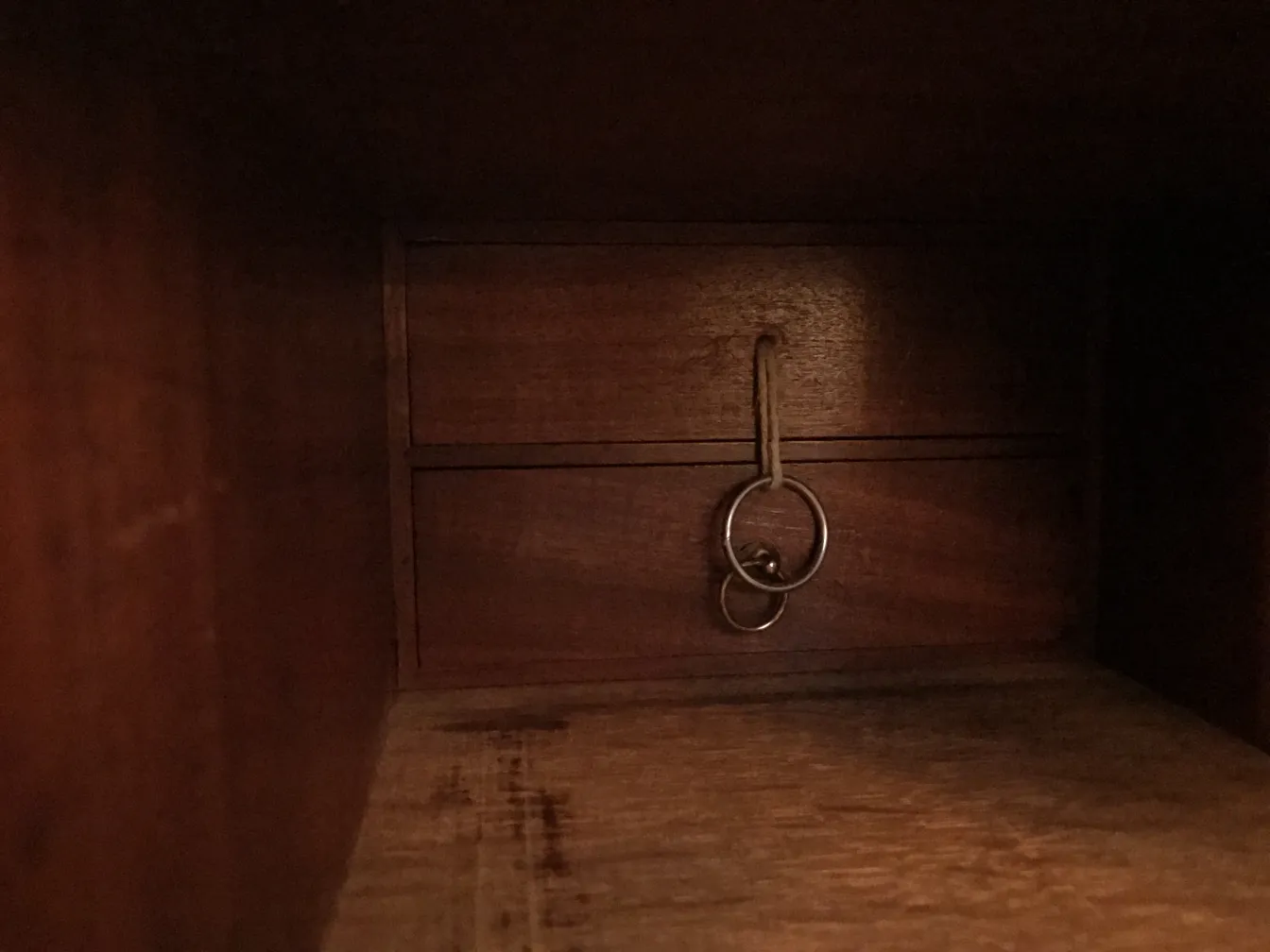 पुराने डेस्क के अंदर, जिसमें एक दराज और लटकी हुई चाबियां हैं.