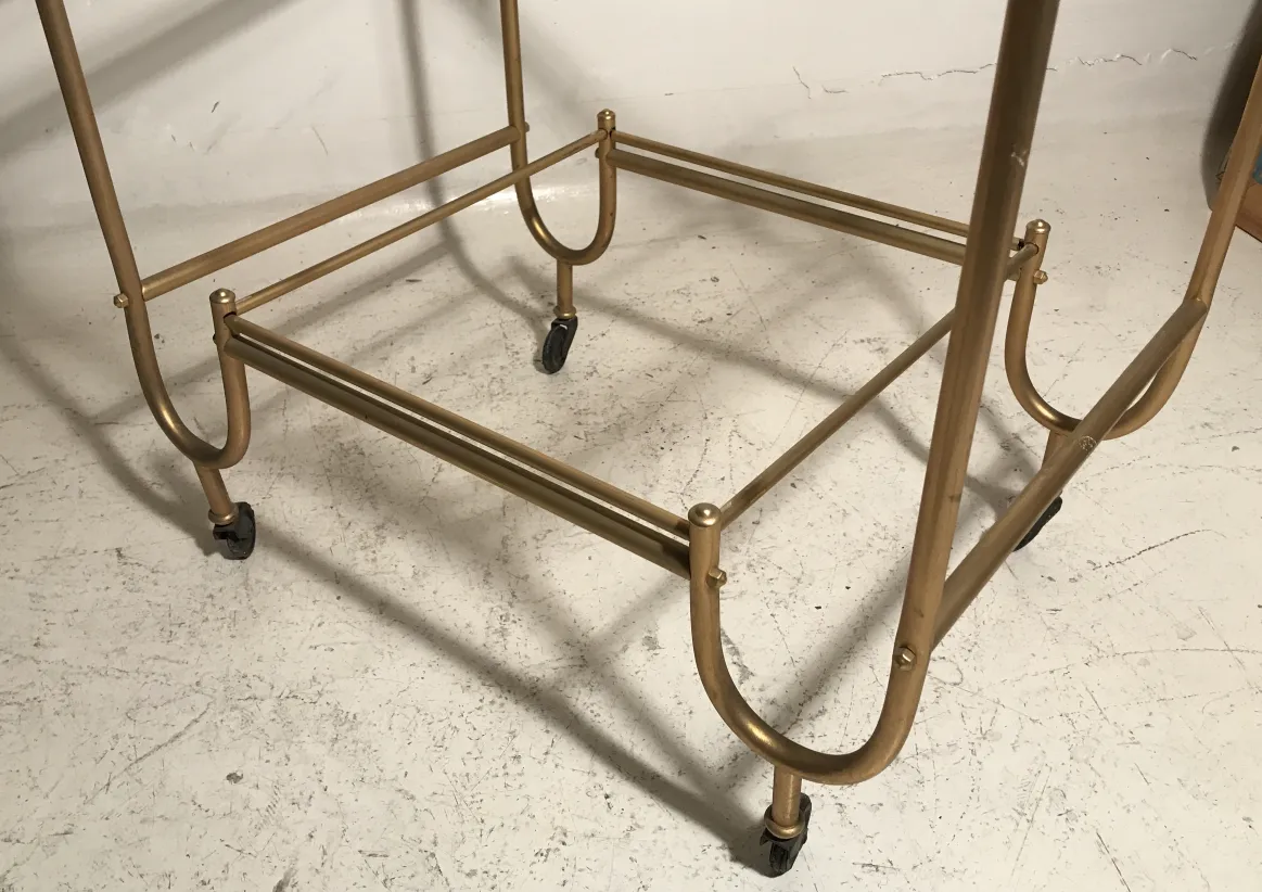 Antique golden cocktail trolley with wheels, elegant design.