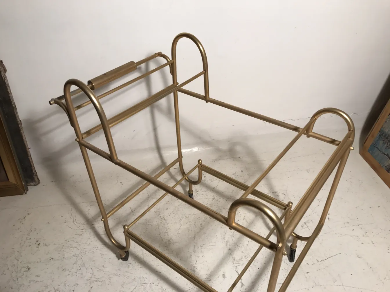 Antique cocktail trolley with a gold frame and classic design.