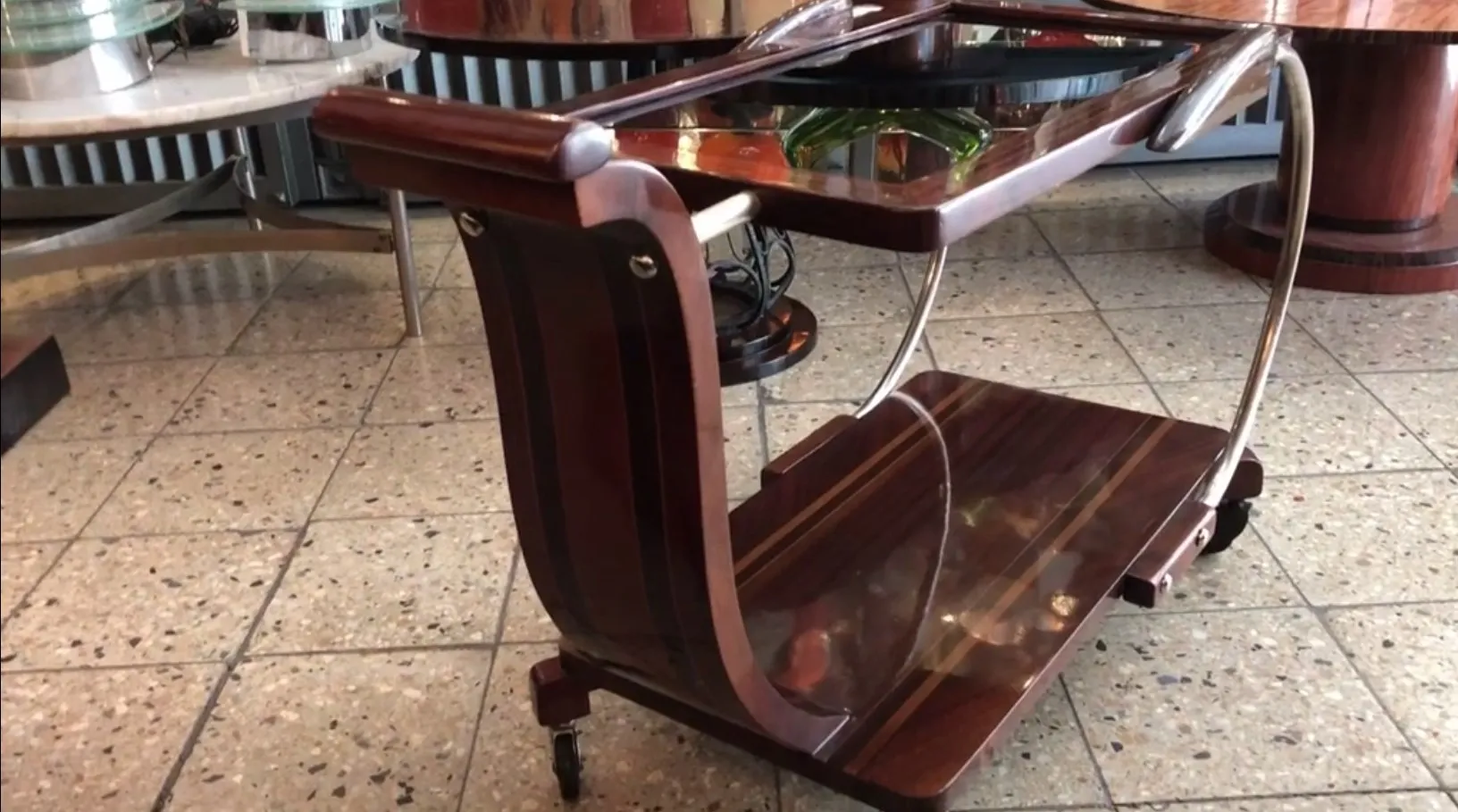 Antique cocktail trolley, dark wood with wheels, elegant setting.