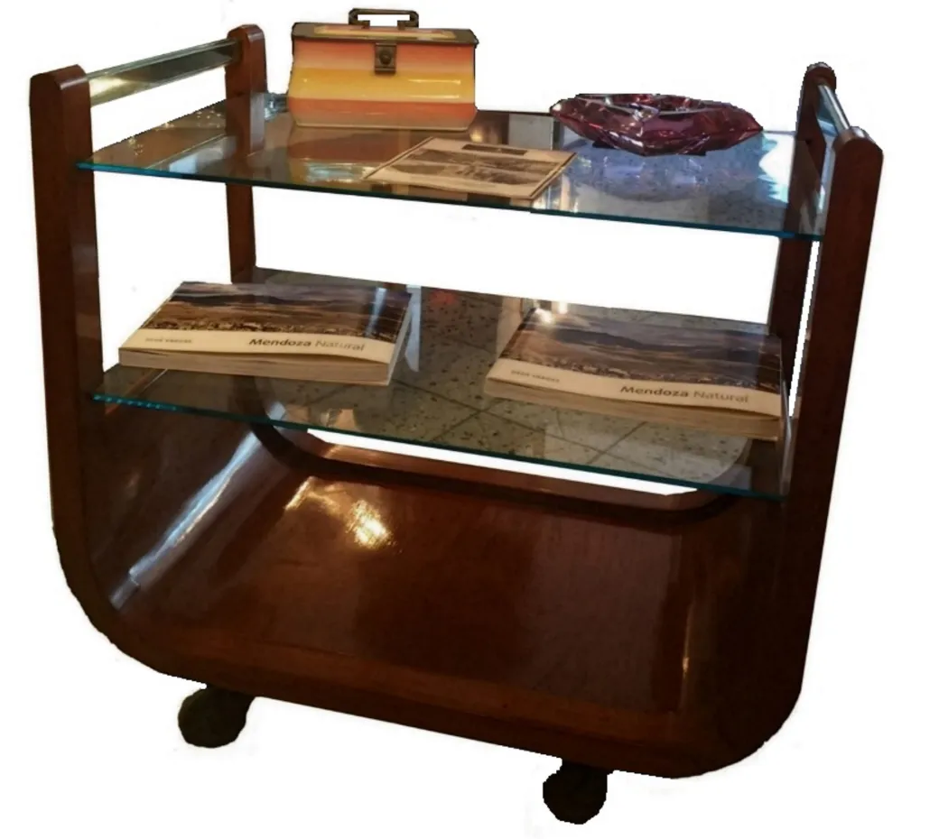 Antique cocktail trolley with glass shelves in a cozy setting.