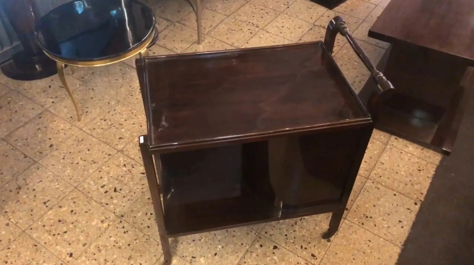 Antique cocktail trolley with two shelves, in a bar setting.