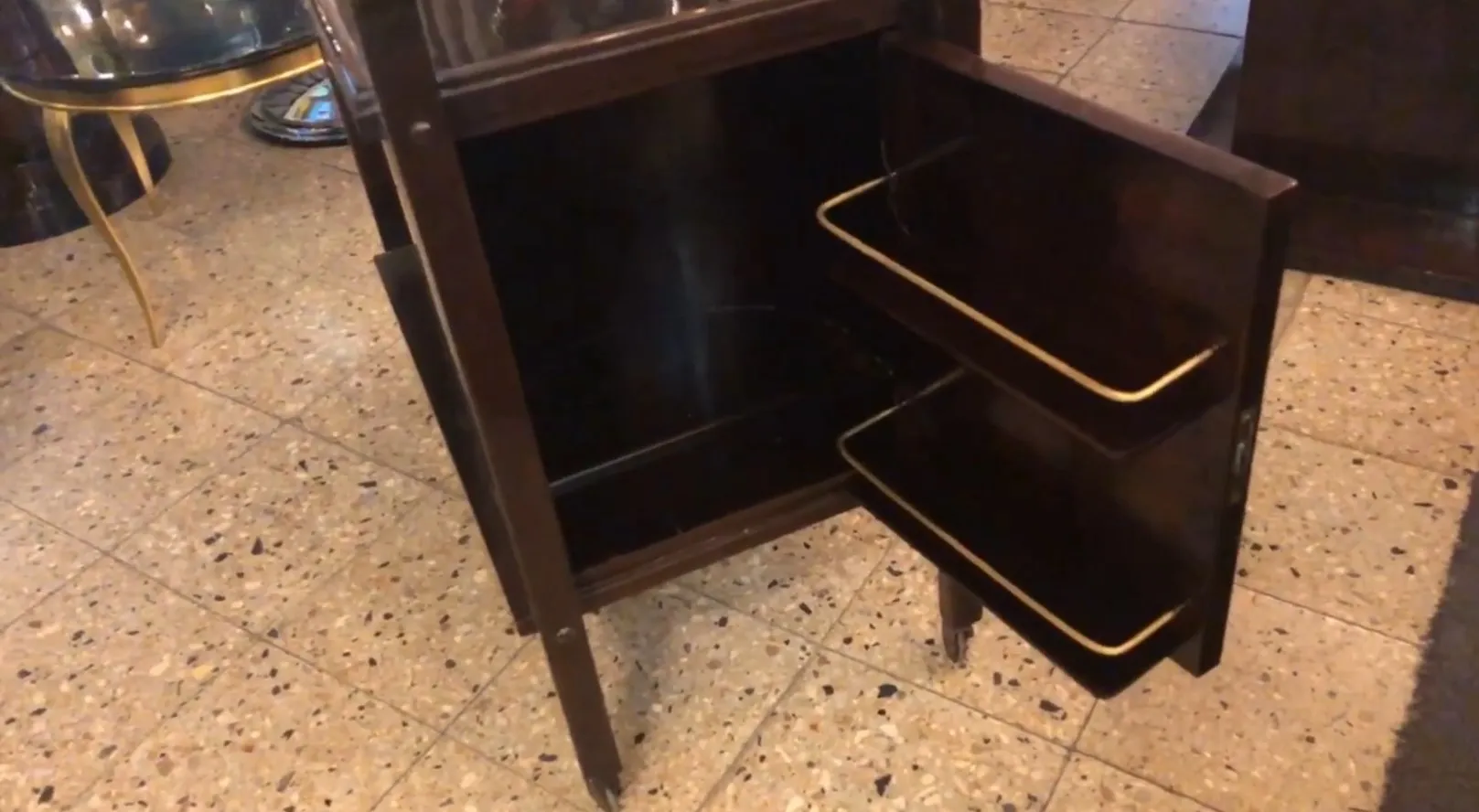 Antique cocktail trolley with gold shelves in an elegant setting