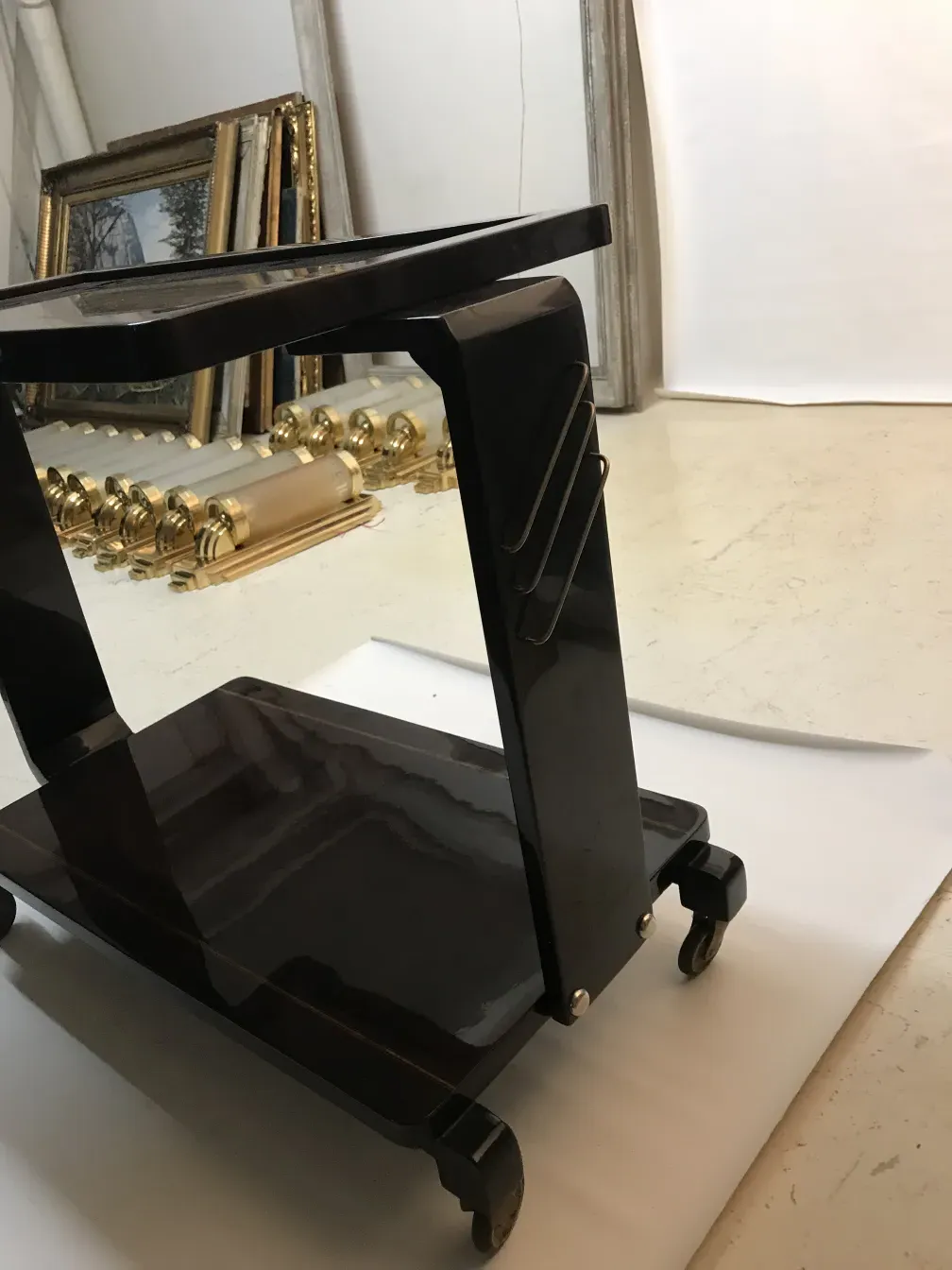 Antique black cocktail trolley with decorative hooks.