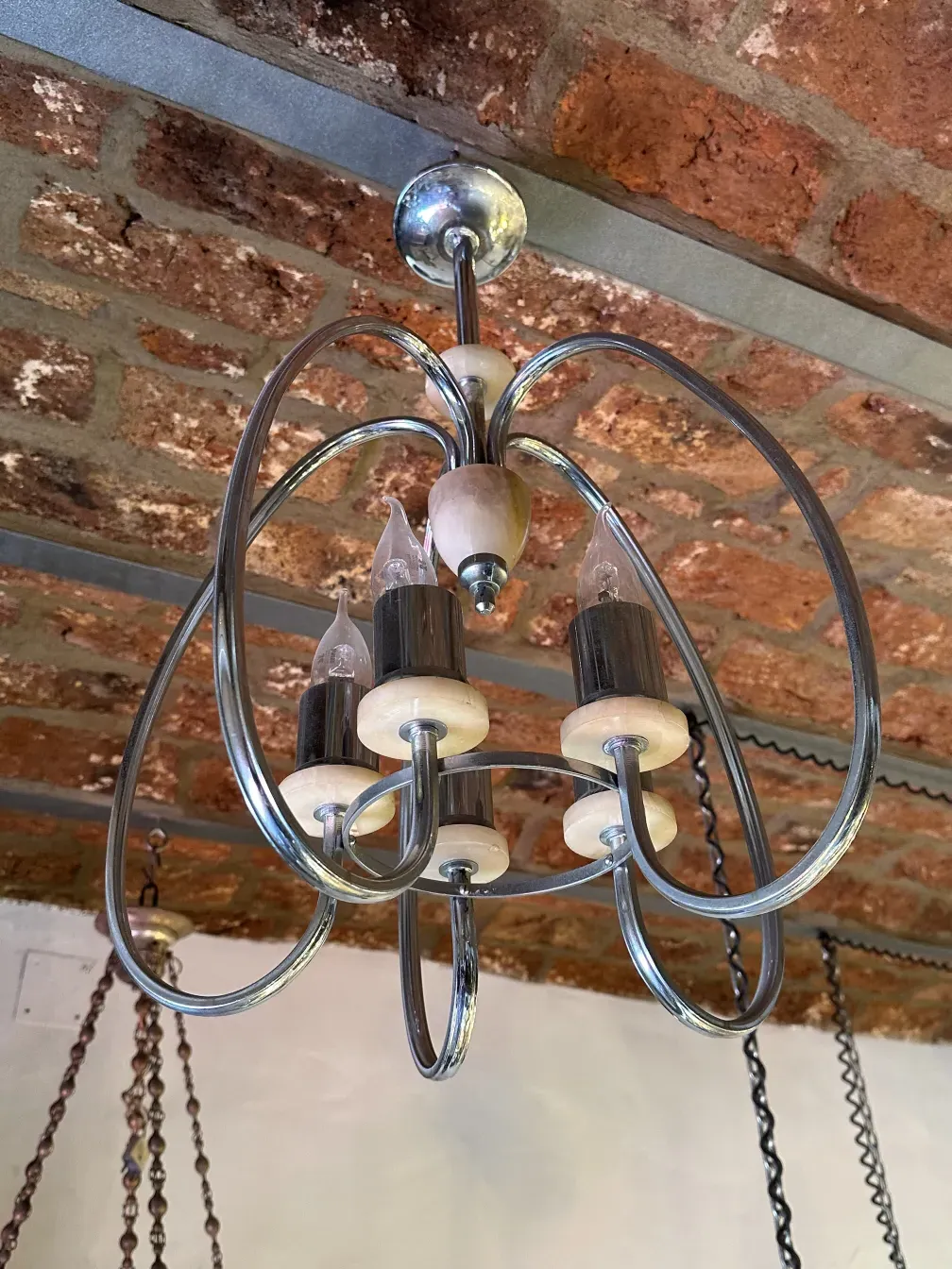 Antique hanging lamp with a modern design, located in a room with brick walls