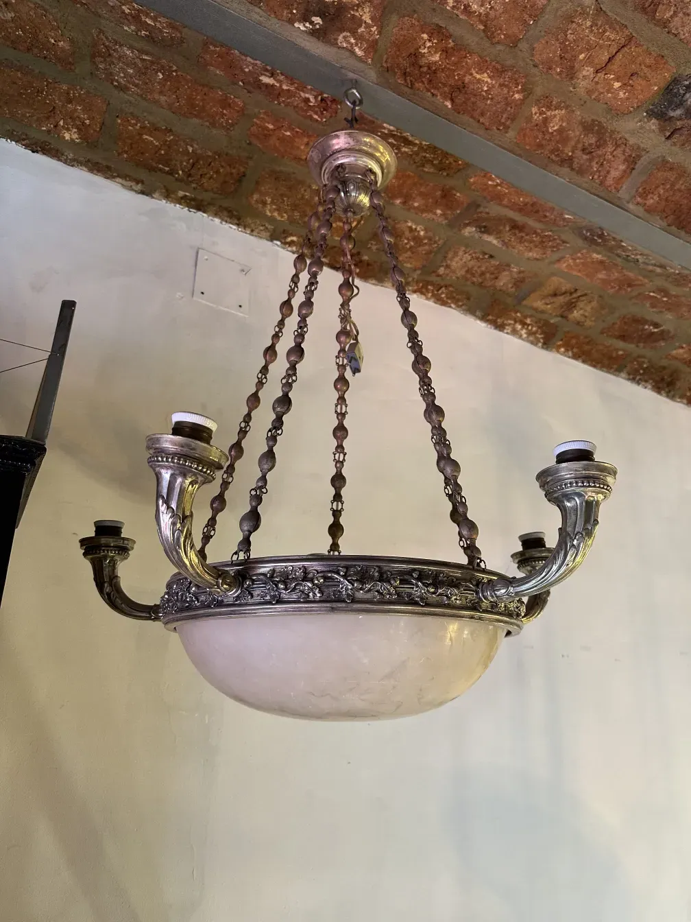 Antique hanging lamp in a rustic setting with decorative chain