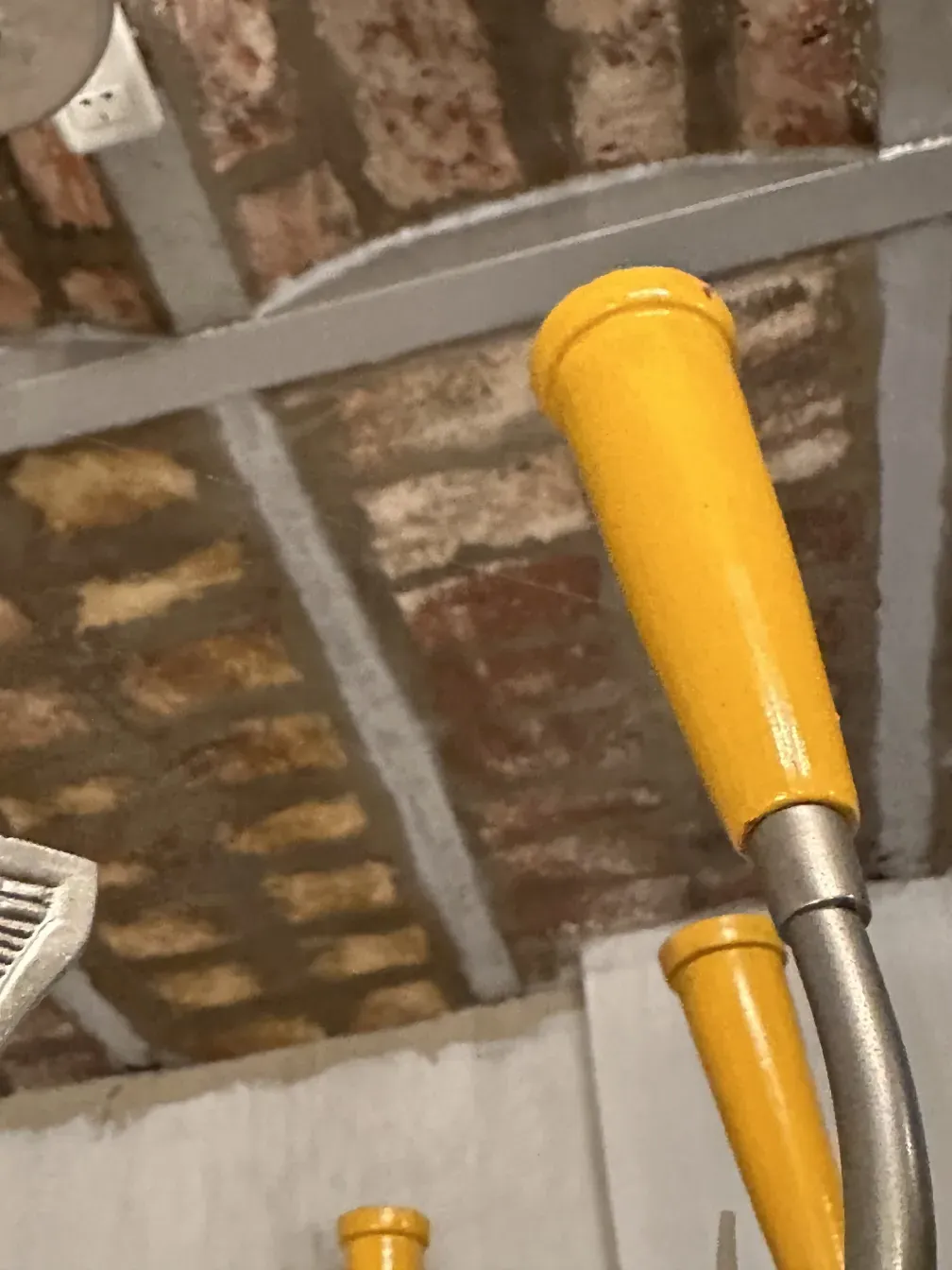 Antique hanging lamp with yellow handles in a rustic setting