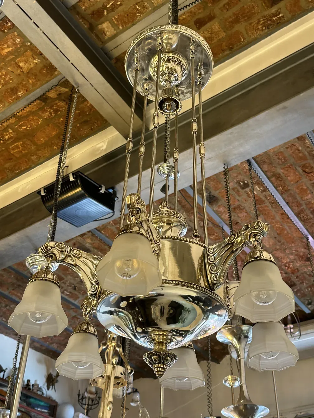 Antique hanging lamp with white shades and multiple lights, cozy ambiance.