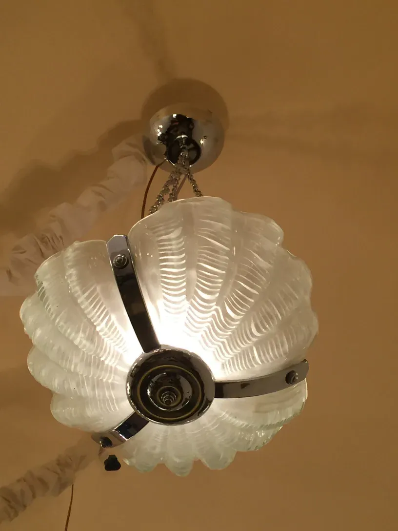 Antique hanging lamp with a decorative floral design, illuminating a warm environment.