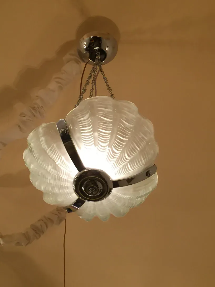 Antique hanging lamp with a shell design and warm light.