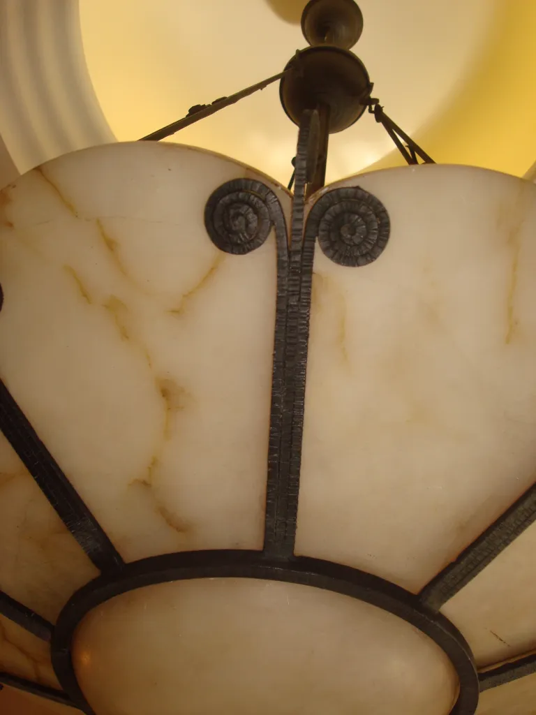 Antique hanging lamp with intricate and elegant design, set in a warm environment.