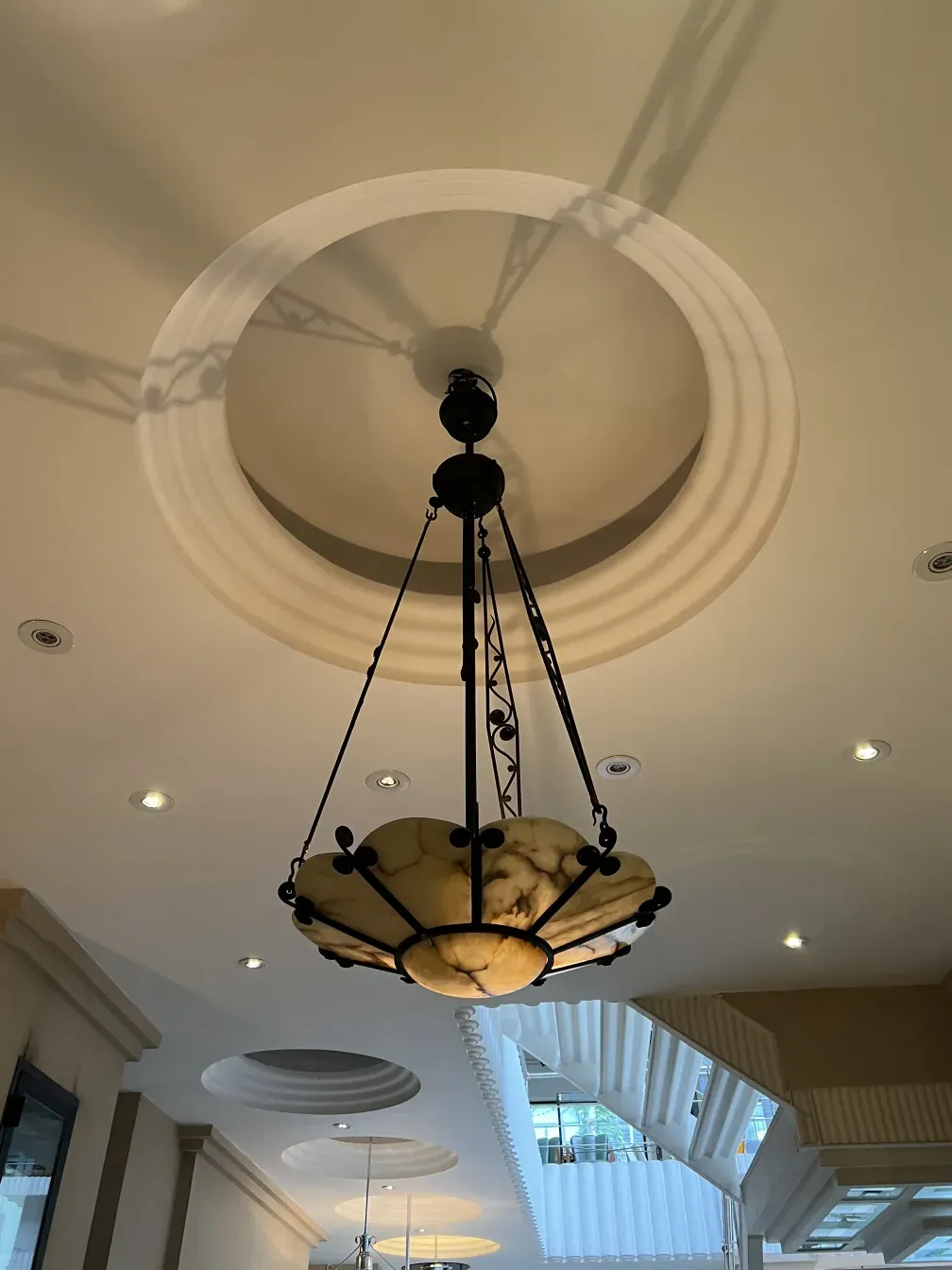 Antique hanging lamp with a marble shade against a light background.