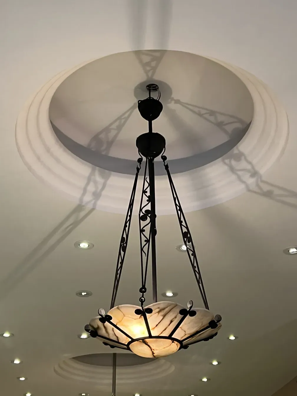 Antique hanging lamp casting a soft light shadow, in a cozy setting.