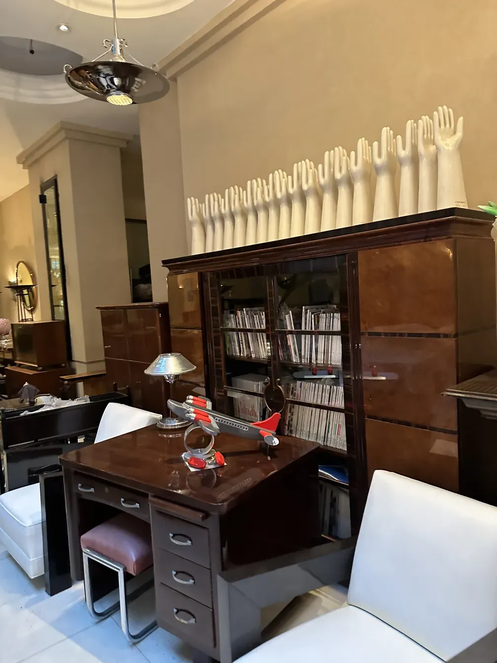 Antique hanging lamp with a shiny finish, in a modern setting. Elegant work desk and decor.