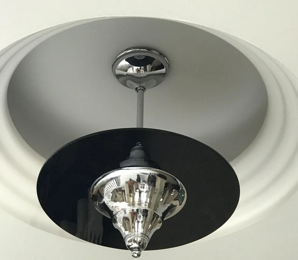 Antique hanging lamp with shiny base in a modern setting.