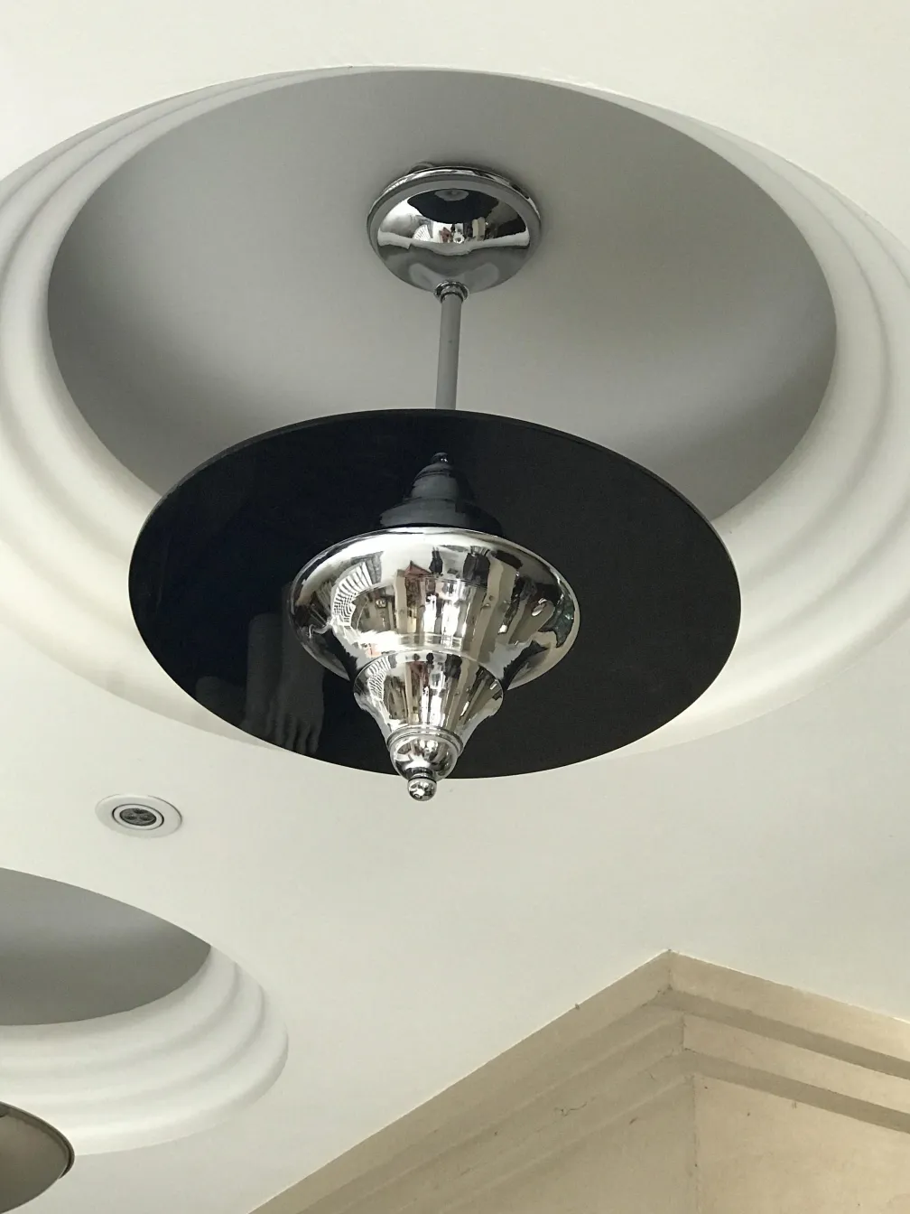 Antique hanging lamp with shiny base and black shade, classy.