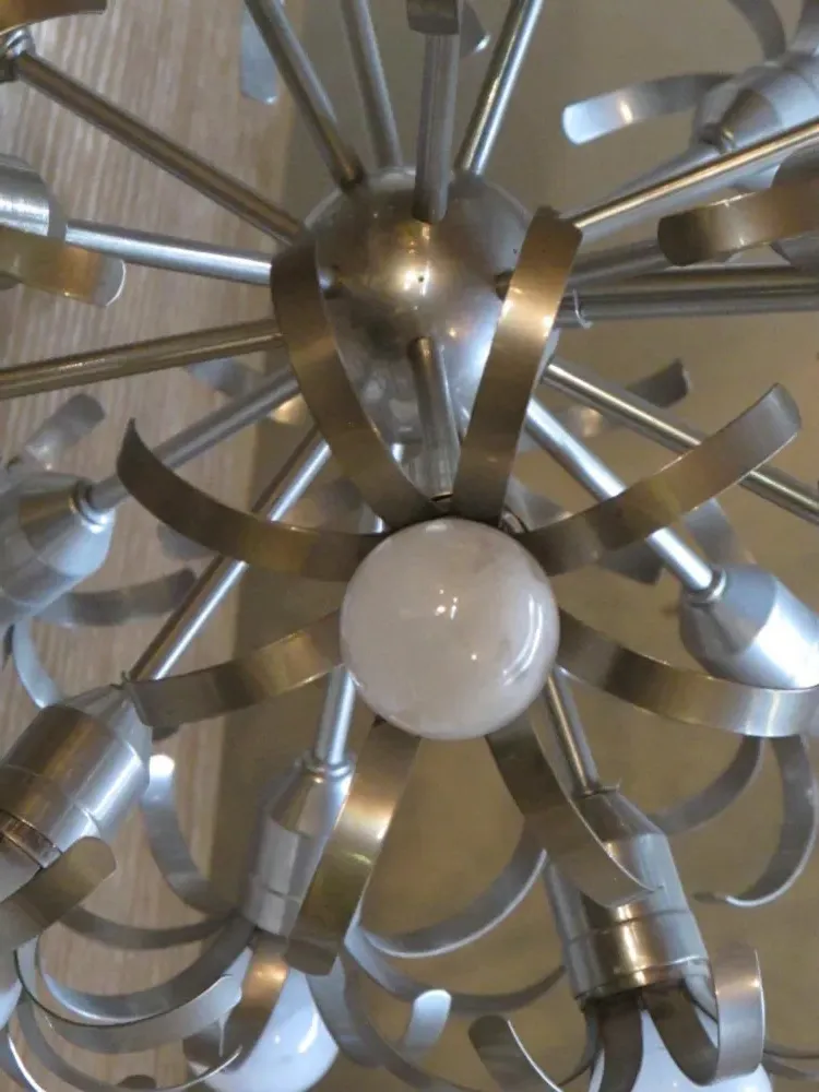 Antique hanging lamp with modern, shiny, metallic design in an elegant setting.