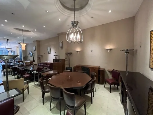 Antique hanging lamp with elegant design, bright lights, in a cozy environment with tables and chairs.