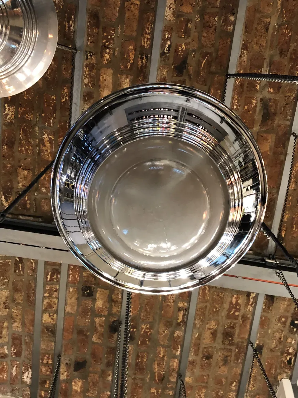 Antique hanging lamp with a bright finish, elegant design in a rustic setting.