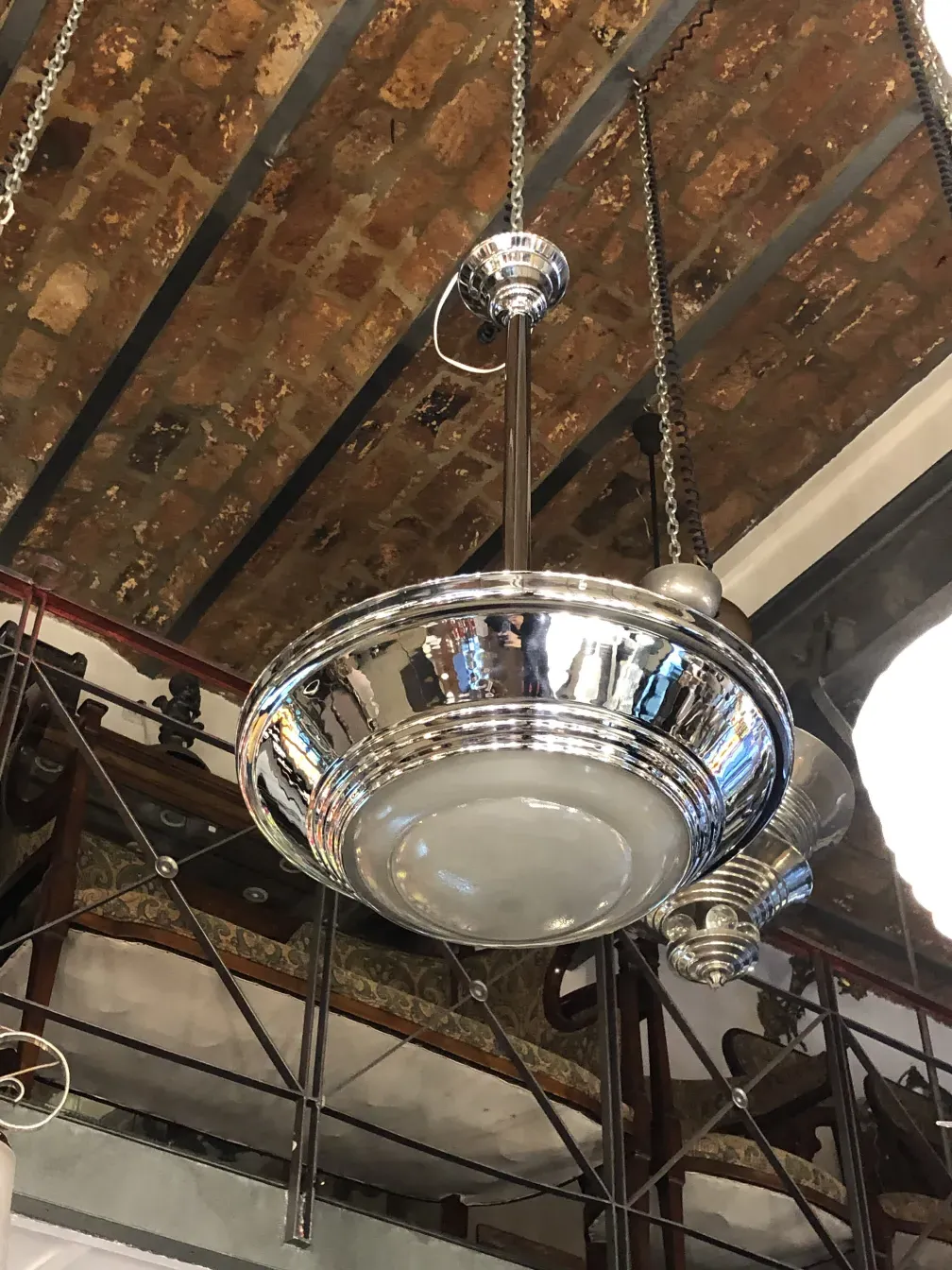 Antique hanging lamp with shine, suspended from a wooden ceiling.