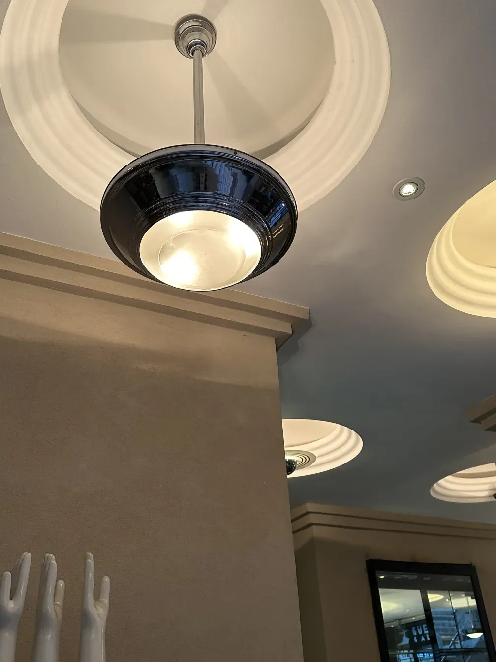 Antique hanging lamp with a sleek modern design, lights in the background.