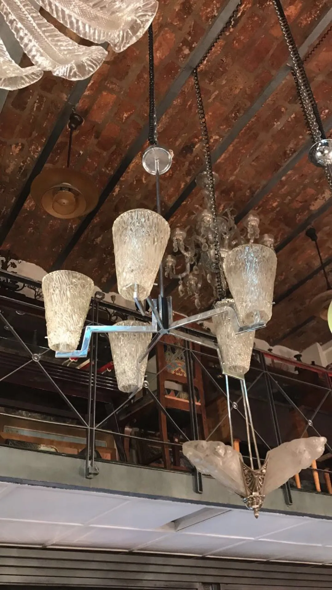 Vintage hanging lamp with five shades and intricate details in a cozy setting.