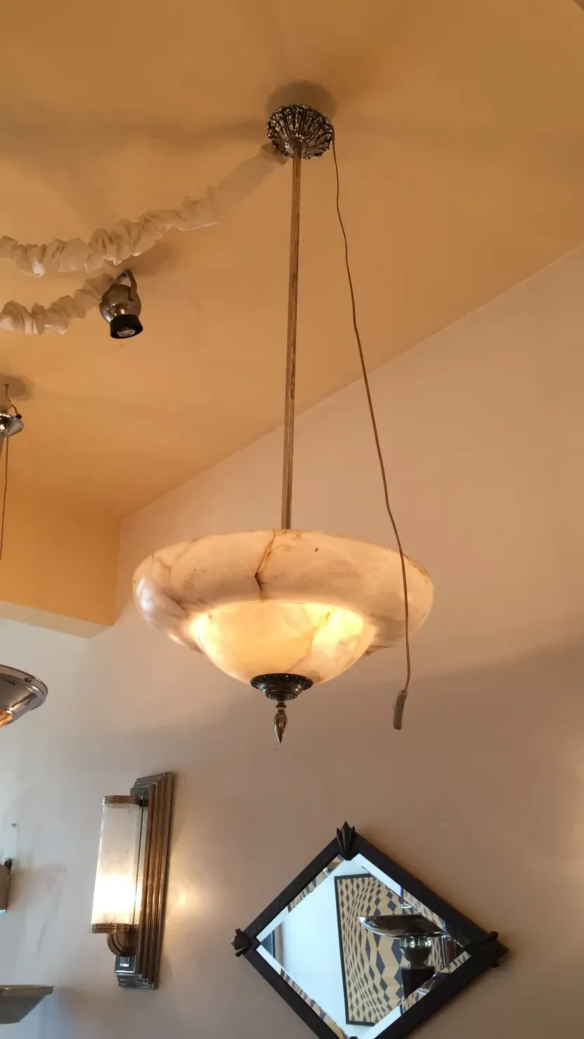 antique hanging lamp made of alabaster, elegant details and soft lighting.