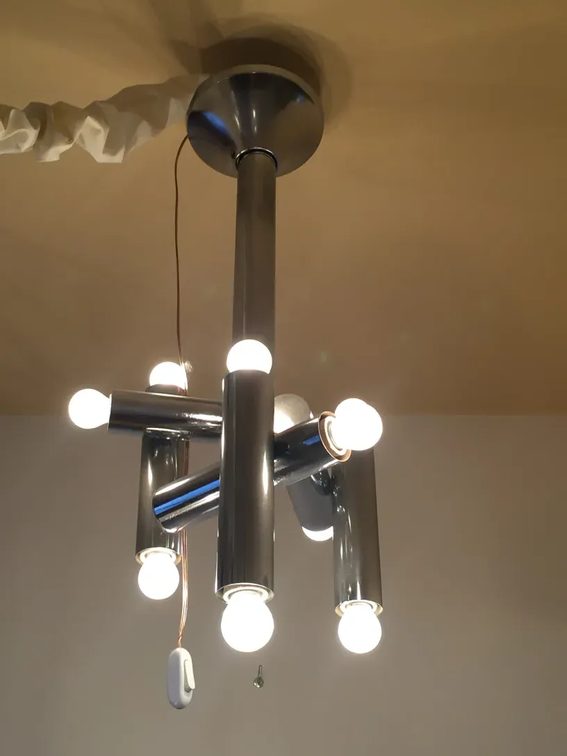 Antique hanging lamp with multiple tubular bulbs illuminating a room
