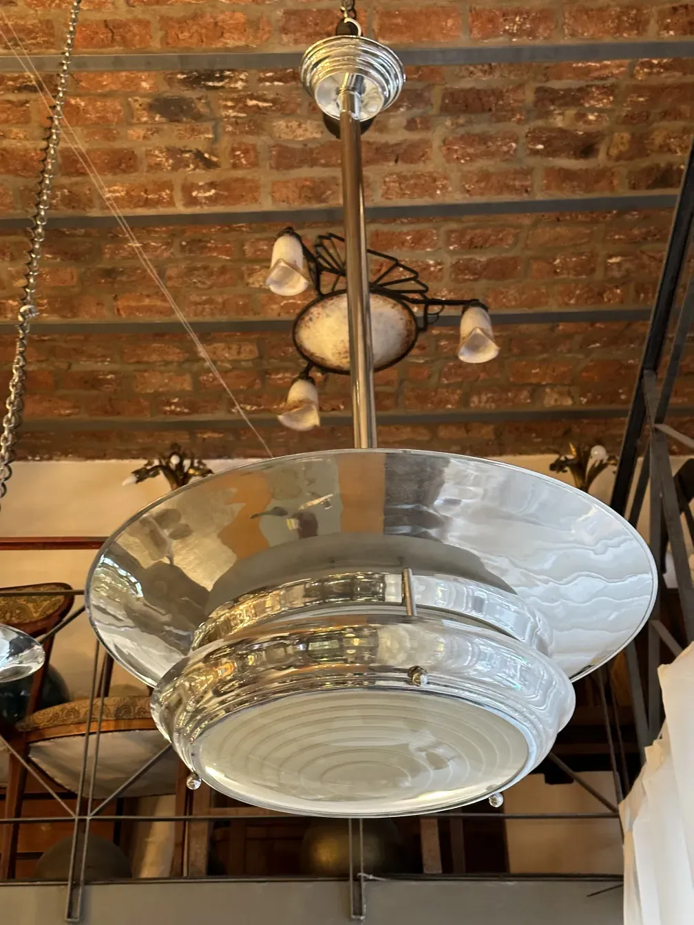 Antique hanging lamp with shiny design in rustic setting.