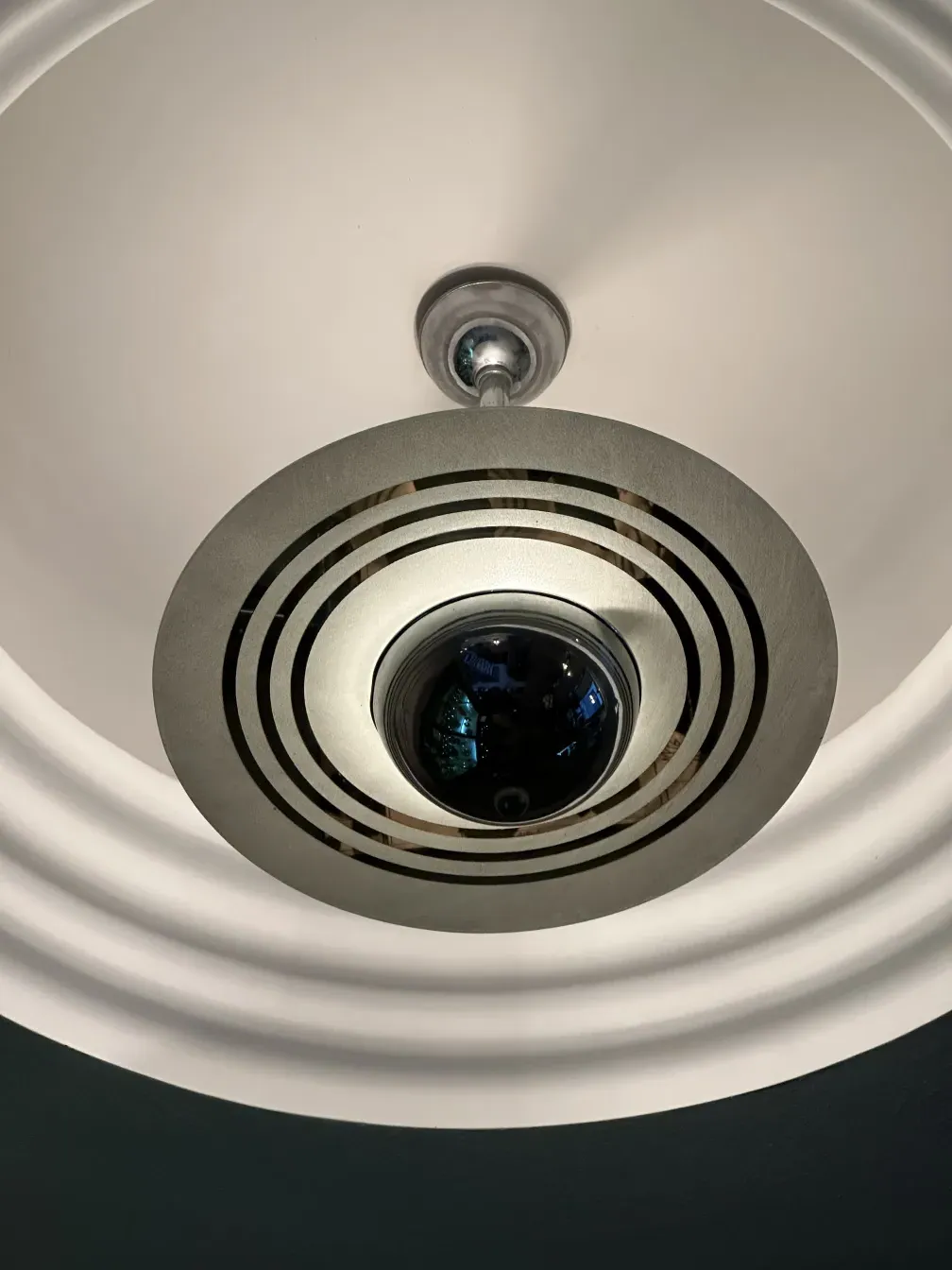 Antique hanging lamp with geometric design at the center.