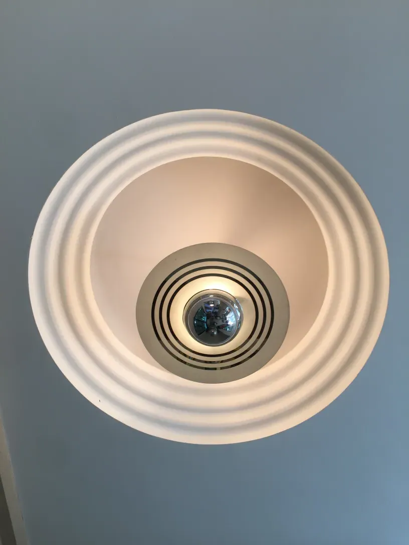 Antique hanging lamp with circular design and reflections.