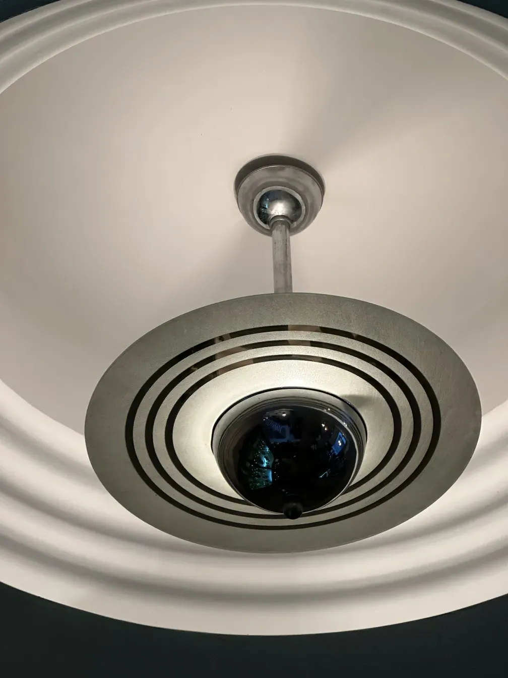 Antique hanging lamp with circular and contemporary designs in a modern setting.