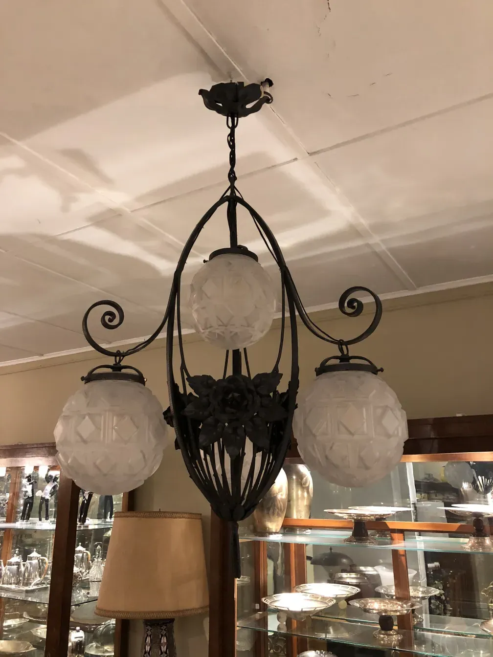 Antique hanging lamp with white glass globes in a cozy setting.