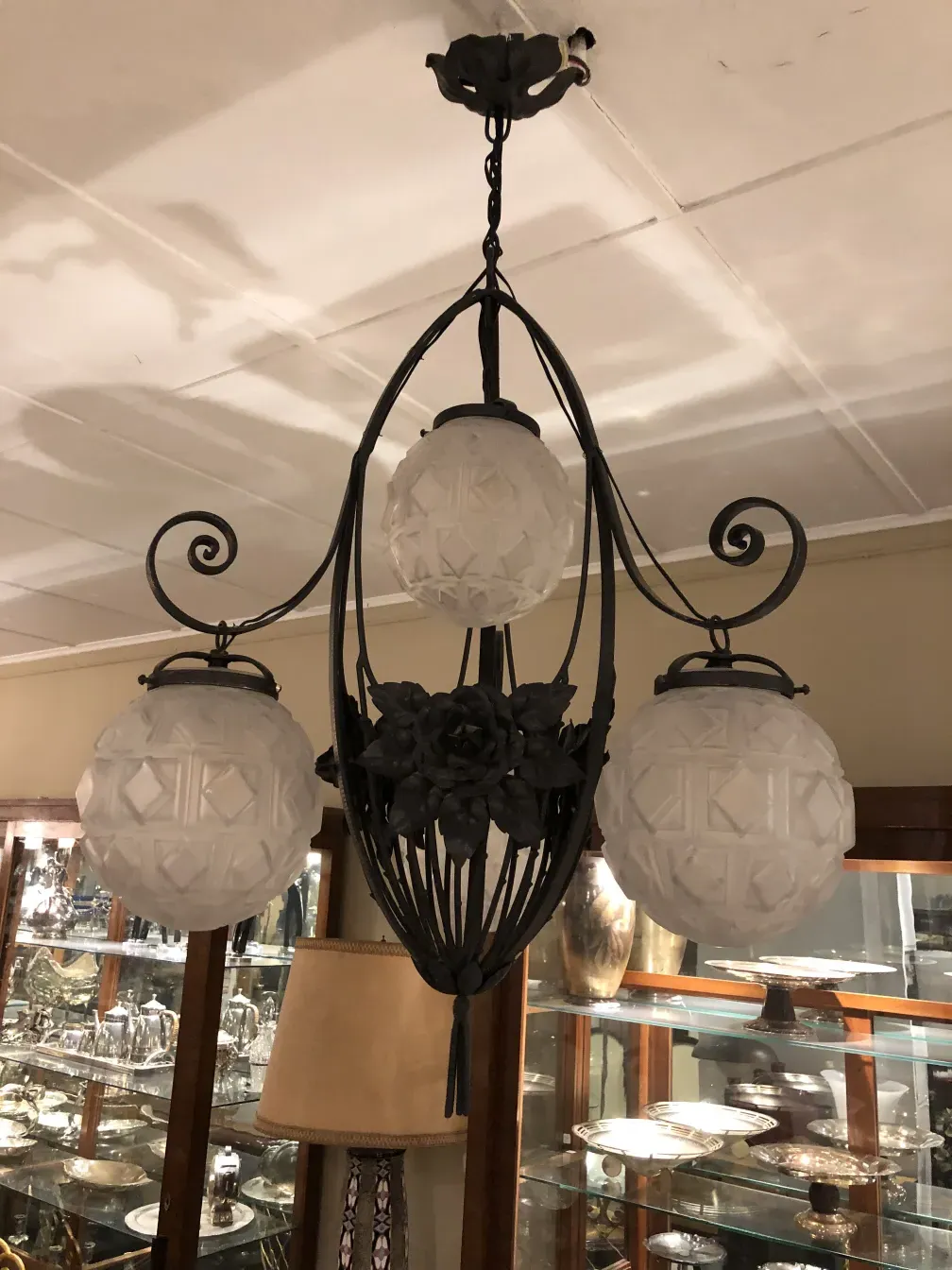Antique hanging lamp with frosted glass spheres, elegant ambiance.