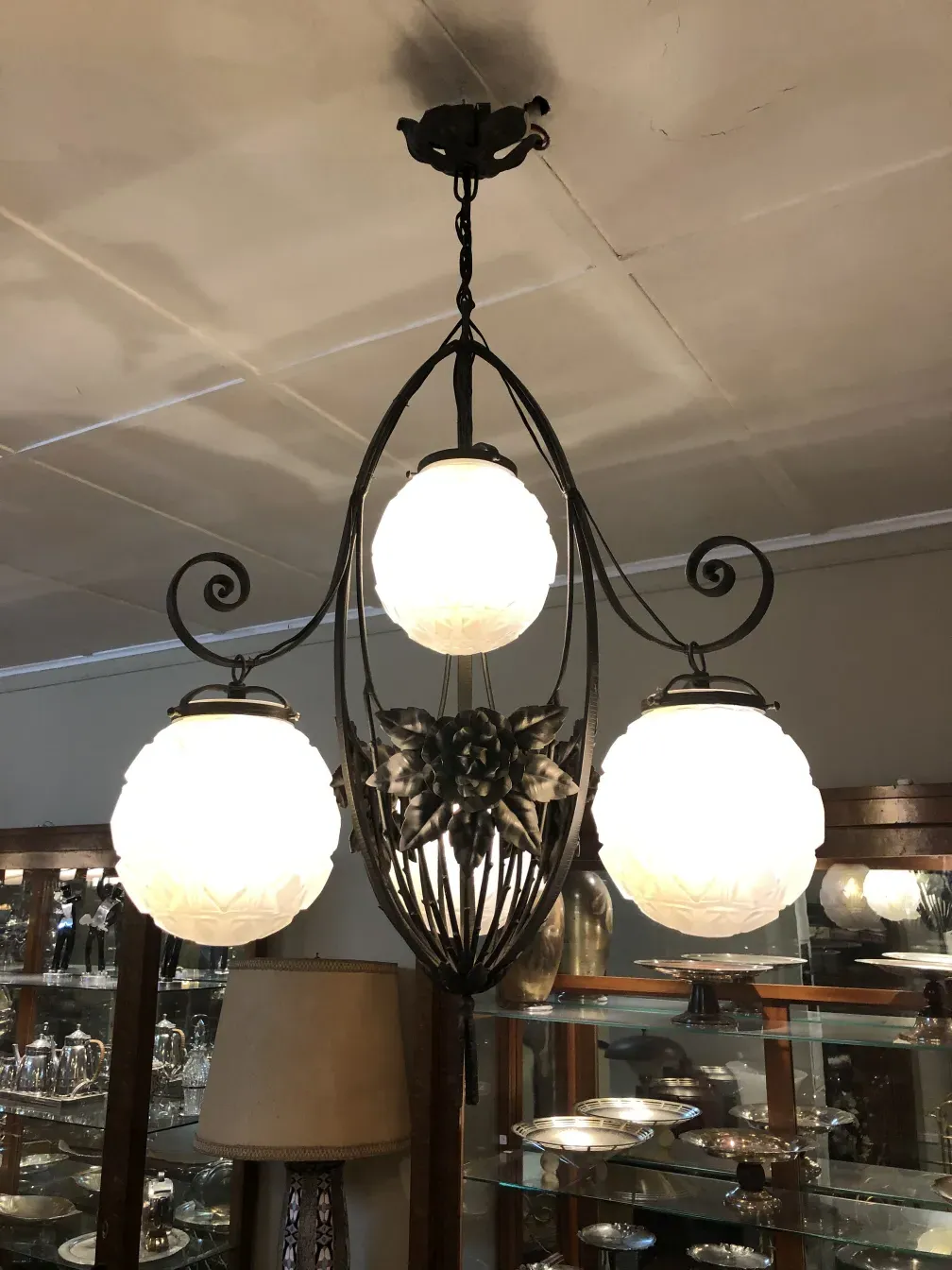 Antique hanging lamp with three glass globes in an elegant setting.