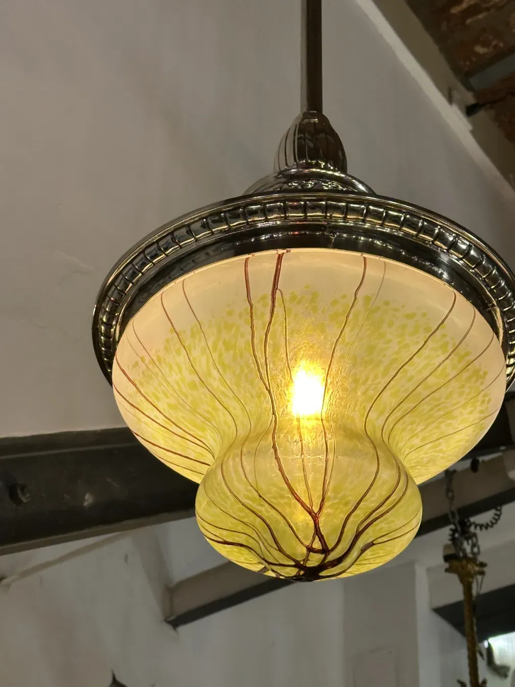 Antique hanging lamp made of colorful glass, illuminating the space, part of a decorative setting.