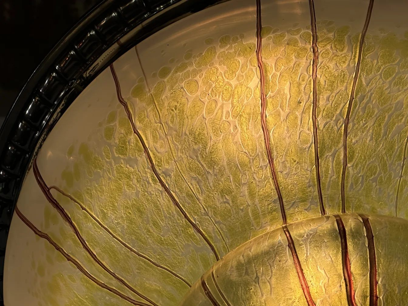 Close-up of the yellow and green interior of an antique hanging lamp