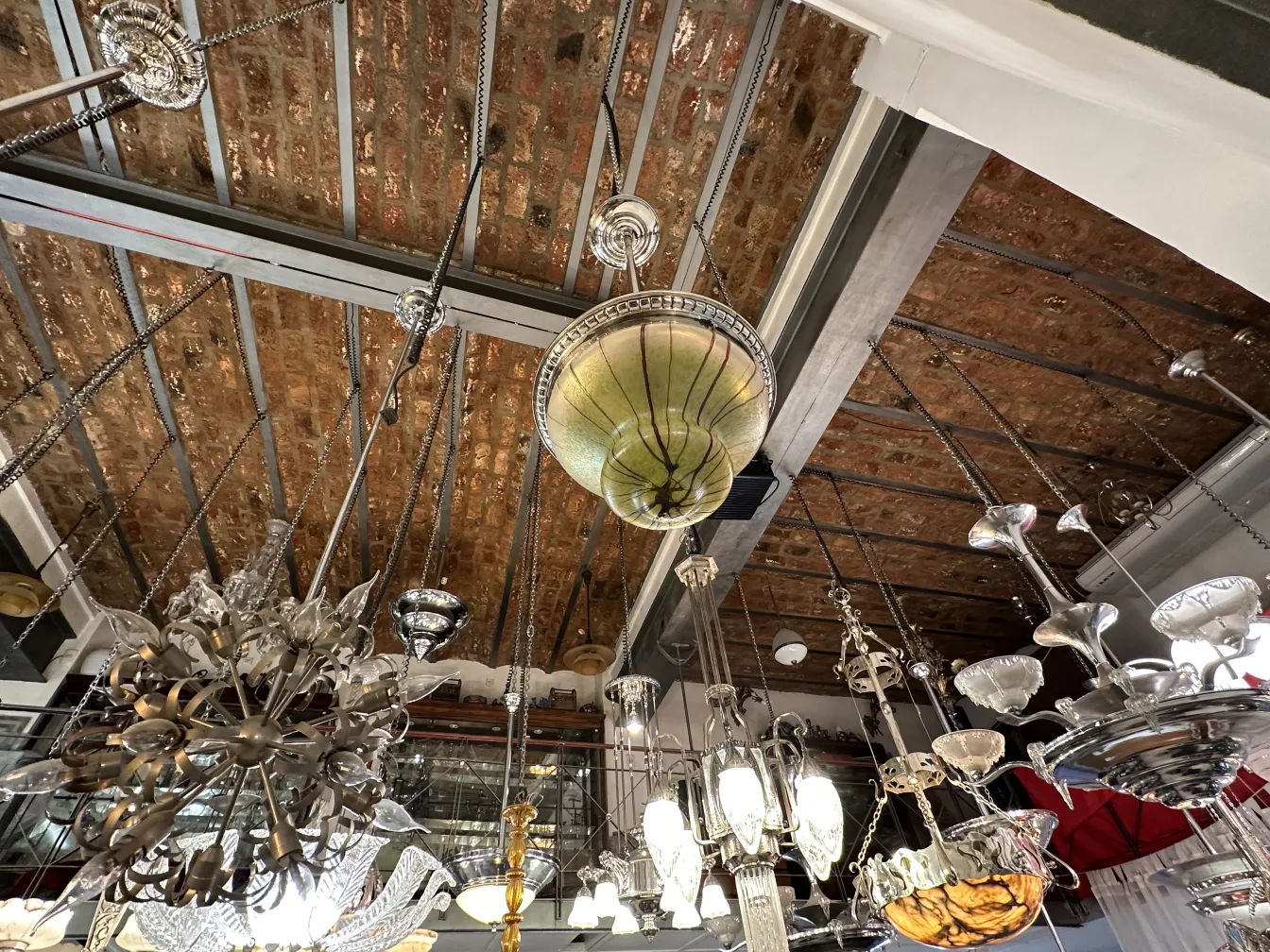 Antique hanging lamp with intricate finishes, surrounded by other lamps.