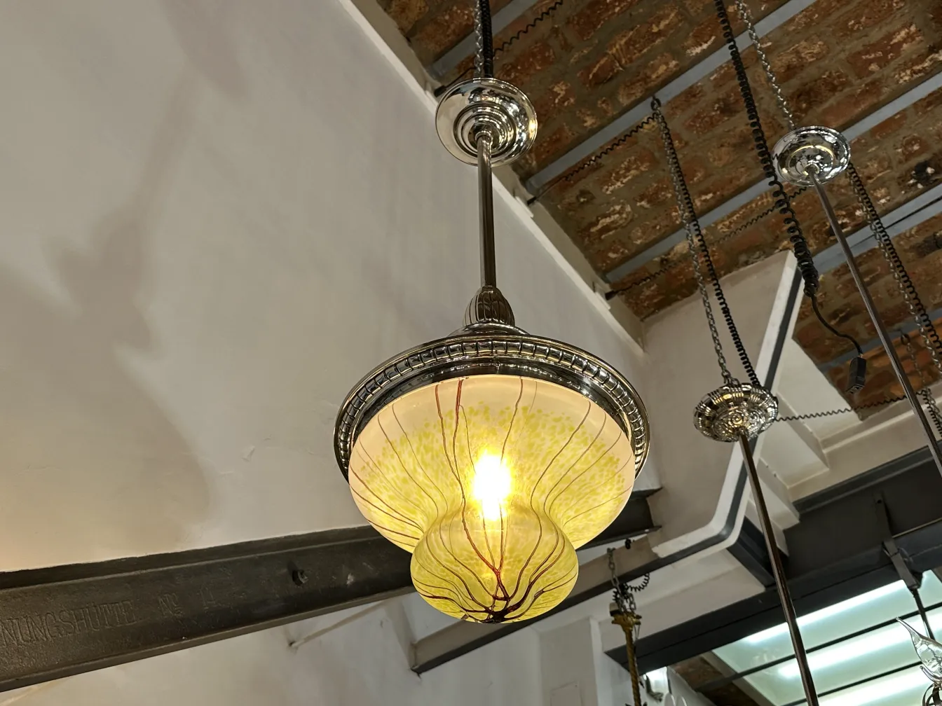 Antique hanging lamp in yellow with intricate details.
