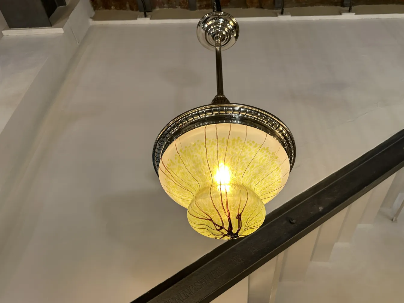 Antique hanging lamp with unique glass details, illuminating a space.