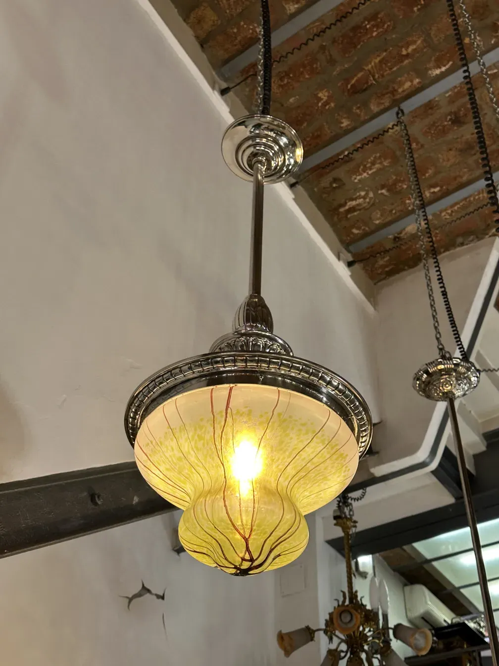 Antique hanging lamp with a bright, colorful design in a cozy setting.