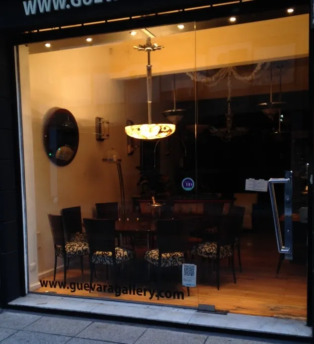 Antique hanging lamp with bright design displayed in a gallery.