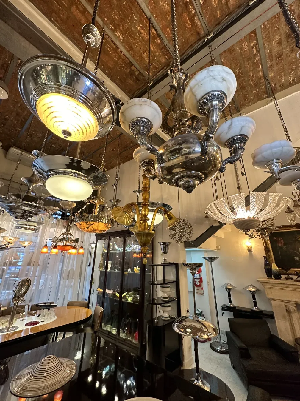 Various antique hanging lamps displayed under a round ceiling.