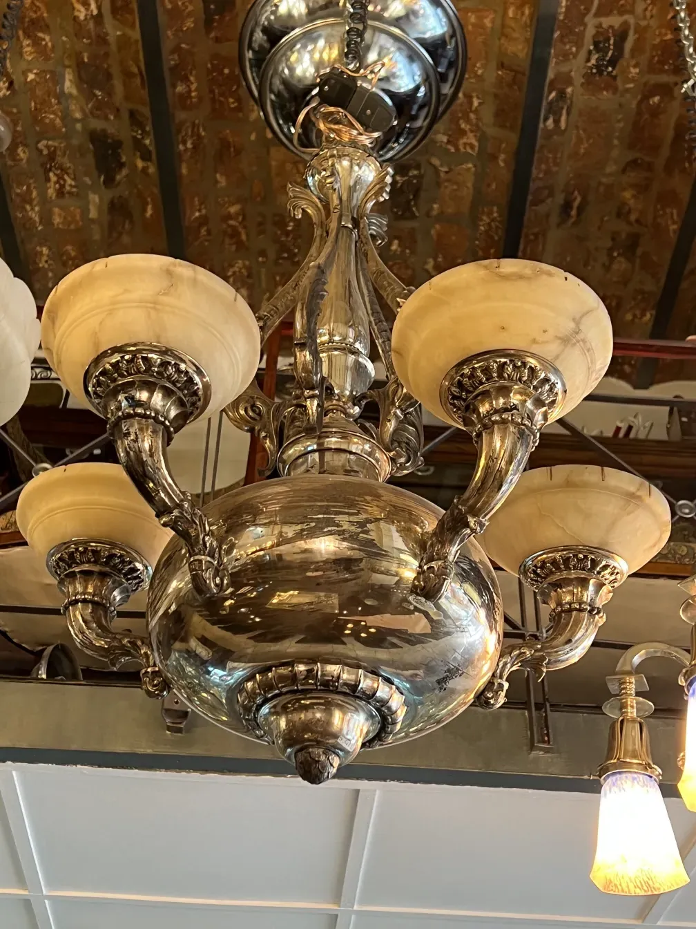 Antique hanging lamp with decorative details and bright lights, elegant setting.