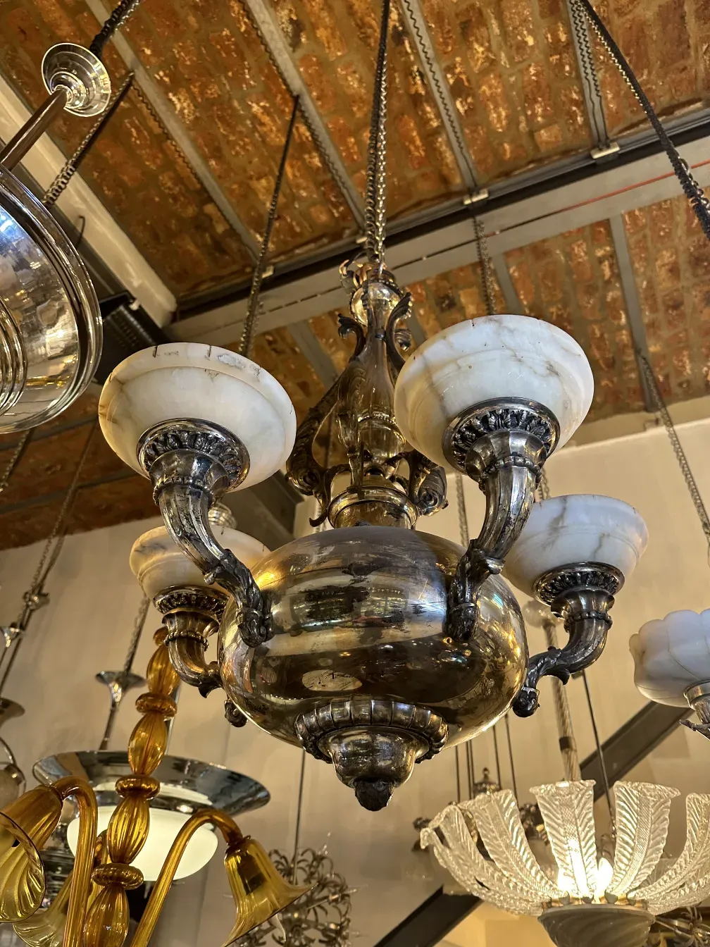 Antique hanging lamp with metal base and marble shades in an antique setting.