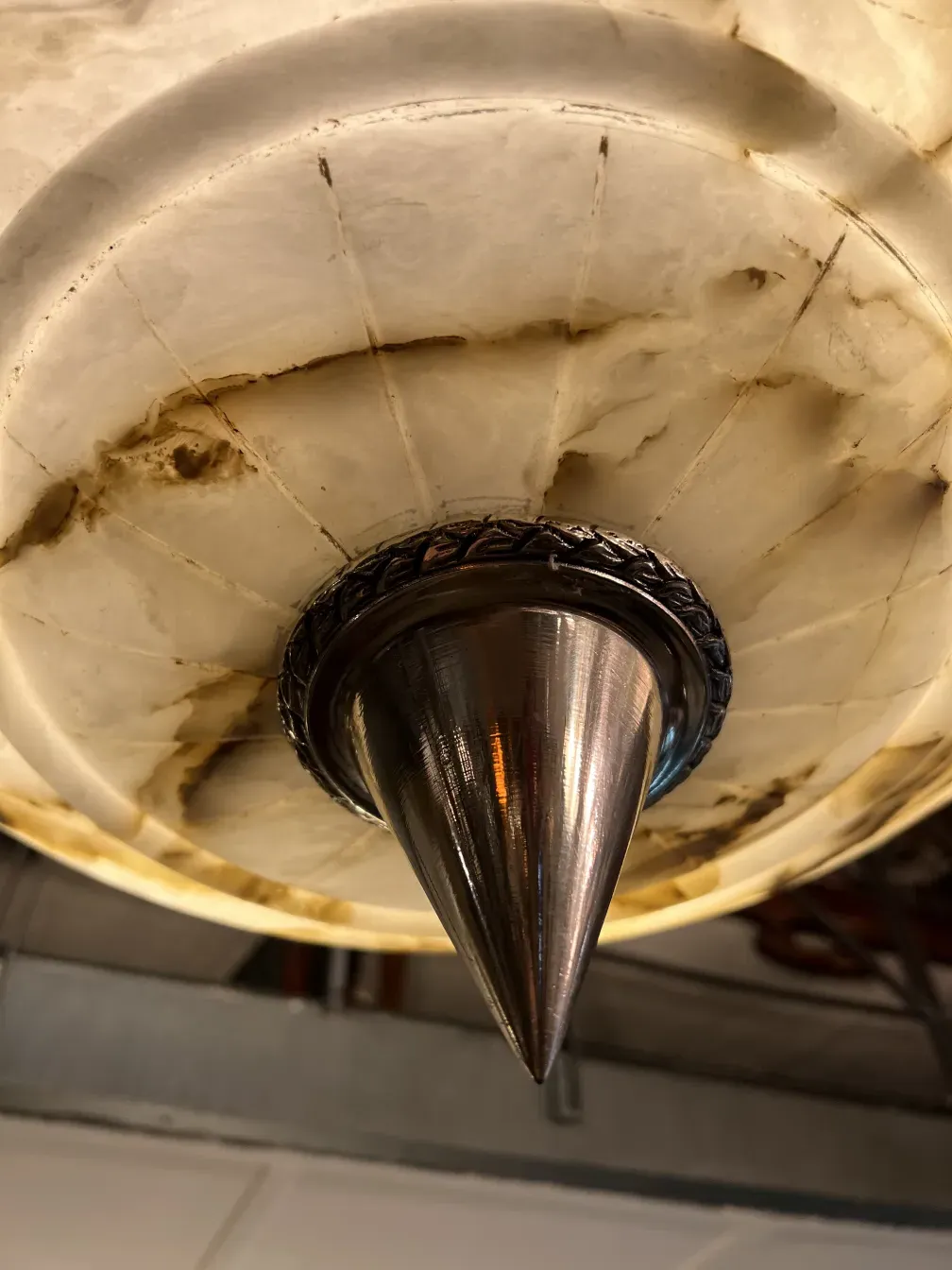 Antique hanging lamp crafted from alabaster with decorative details. Warm and inviting atmosphere.