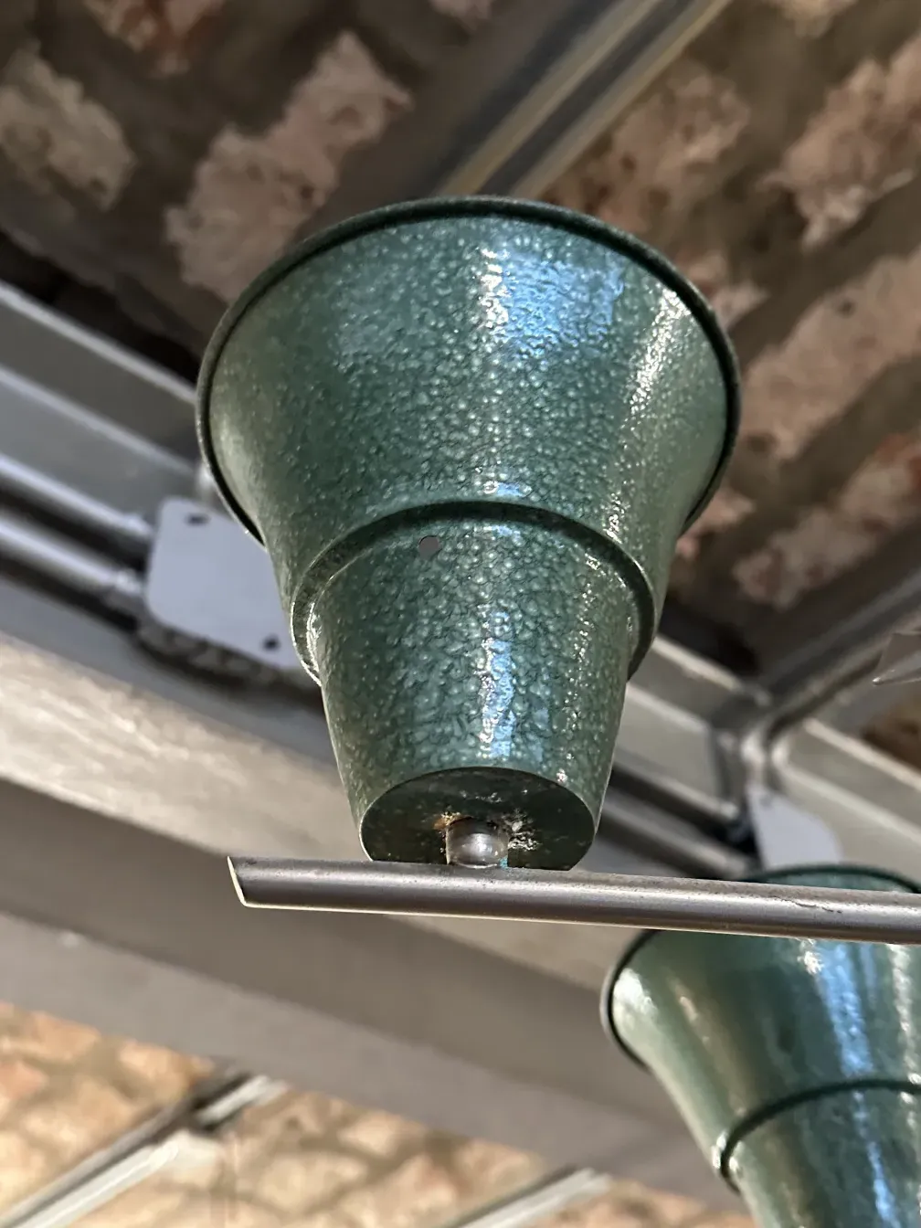 antique green hanging lamp with appealing design in rustic setting.