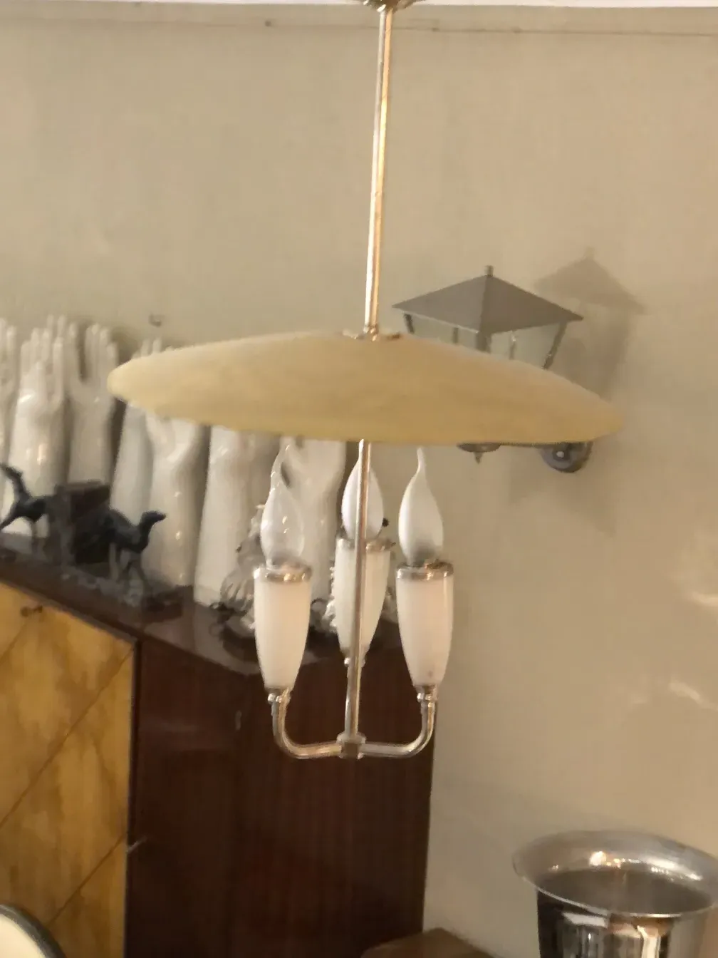 Antique hanging lamp with three white lights in a classic setting.
